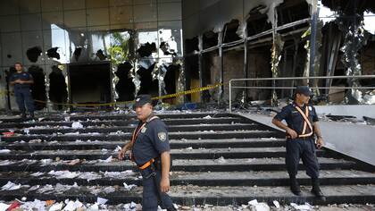 Police officers guard the Congress entrance in Asuncion, Paraguay, Saturday, April 1, 2017. Protesters stormed Paraguay&amp;apos;&amp;apos;s Congress building  Friday night, setting it on fire after a secret Senate vote to approve a bill that would allow President Horacio Cartes to run for another t