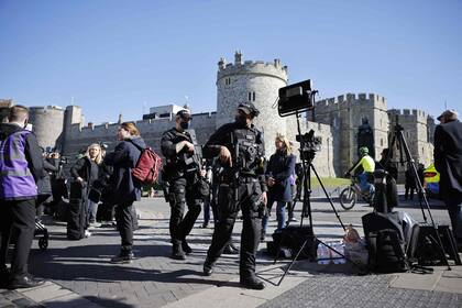 Un oficial de policía camina junto a los medios de comunicación fuera del Castillo de Windsor
