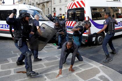 Policías antidisturbios se enfrentan con inmigrantes indocumentados fuera del Panteón en París, Francia