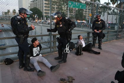Policías arrestan a dos hombres en medio de protestas en Los Ángeles el 14 de junio del 2025. (AP foto/Ethan Swope)
