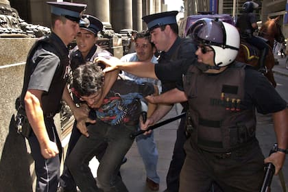 Policías detienen a un hombre durante los disturbios