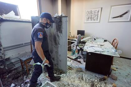 Policías evalúan los daños producidos por las llamas en la Legislatura provincial. Se estima que en los edificios públicos atacados la reparación costará más de 50 millones de pesos.
