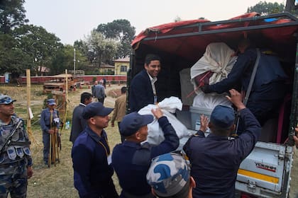 Policías llevan las urnas a un vehículo que las llevará a un centro de conteo tras el cierre de un centro de votación para las elecciones parlamentarias, en Katmandú, Nepal