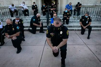 Policías se arrodillan en Coral Gables, Miami, en un gesto de solidaridad hacia las víctimas de la violencia racial.