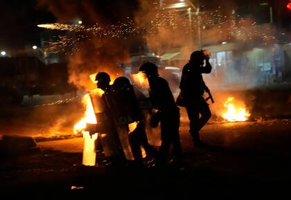 Policías se enfrentan en medio de barricadas incendiadas a manifestantes en Chao, noroeste de Perú, el viernes 17 de febrero 