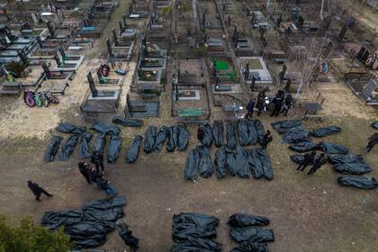 Policías trabajan en el proceso de identificación tras el asesinato de civiles en Bucha, antes de enviar los cuerpos a la morgue, en las afueras de Kiev, Ucrania, el miércoles 6 de abril de 2022. 