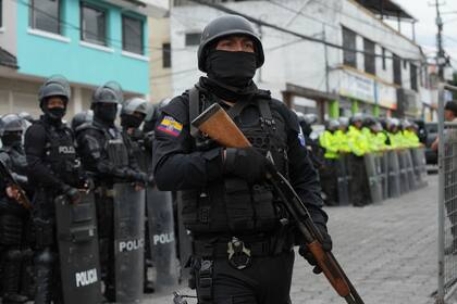 Policías y soldados se encuentran afuera de la prisión El Inca después de que comenzaron los disturbios en el interior en Quito, Ecuador, el lunes 8 de enero de 2024. El motín se produce un día después de que las autoridades ecuatorianas informaron que, en otra prisión diferente en la ciudad de Guayaquil, el líder de la pandilla Los Choneros Adolfo Macías, alias "Fito", no se encontraba en su celda. Hace una década, el capo huyó de otra instalación. (Foto AP/Dolores Ochoa)