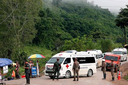 Policías y soldados tailandeses aseguran el área mientras las ambulancias manejan durante la operación de rescate