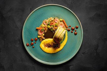 Pollo campestre relleno con mousseline de hongos, sobre emulsión de maíz caramelizada con azúcar mascabo, acompañado de cuscús de piñones asados y vegetales encurtidos.