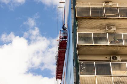 Pomar, en altura, durante el proceso de su obra en la pared del edificio de Villa Crespo