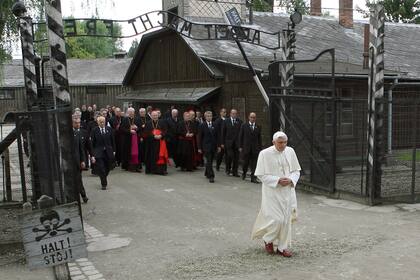 Una foto tomada el 28 de mayo de 2006 muestra al Papa Benedicto XVI pasando la puerta cuando llegó para orar frente al muro de la muerte en el patio del bloque 11 durante una visita al antiguo campo de exterminio de Auschwitz, en Oswiecim, durante su último día de un viaje de cuatro días a Polonia