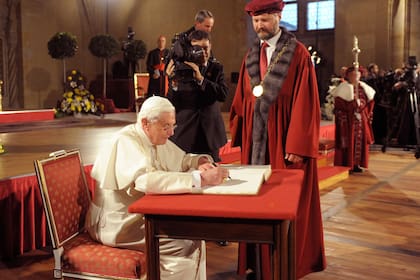 El Papa Benedicto XVI firma un libro durante una reunión con representantes del mundo académico en Praga, República Checa, el domingo 27 de septiembre de 2009