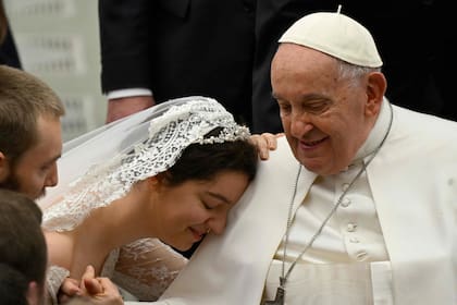 Una novia apoya su cabeza en el hombro del Papa Francisco durante la audiencia general semanal del 28 de febrero de 2024 