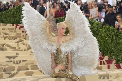 “Cuerpos celestiales: moda e imaginario católico” fue el tema de la Met Gala 2018. Katy Perry tomó nota de inmediato y llegó a la gala con un look que más que inspiración era el resultado de una interpretación literal: fue vestida de ángel. Sobre un vestido corto dorado de Versace, la cantante usó una malla que cubría tanto la prensa como los brazos. Y arriba, unas monumentales alas confeccionadas con plumas