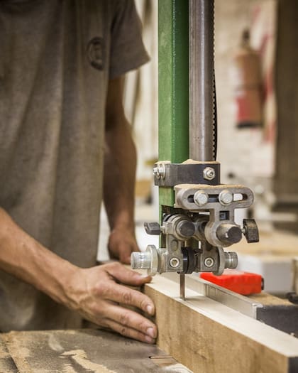 Por esta sierra angular pasan las piezas que terminan formando un mueble. Aquí, las patas de una mesa.