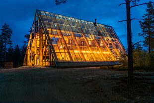 Por la noche, la casa ilumína con energía solar los arbustos más allá de su perímetro.