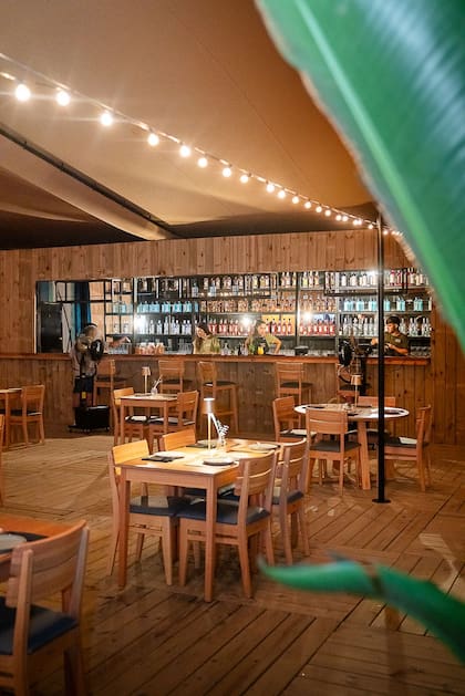 Por las noches, las luces se encienden bajo la gran carpa que cobija las mesas