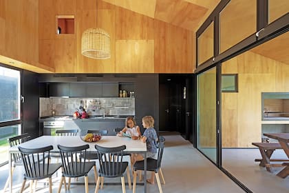 El plano negro contiene la banda de servicios que corresponden a la cocina así como al hall, que distribuye a la escalera posterior, al baño y a los dos dormitorios. Por las rejillas de la cocina sale el aire acondicionado. Los equipos están en una salita técnica junto a la parrilla.