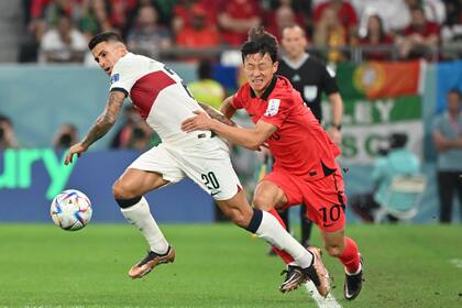 Portugal's defender #20 Joao Cancelo (L) fights for the ball with South Korea's midfielder #10 Lee Jae-sung during the Qatar 2022 World Cup Group H football match between South Korea and Portugal at the Education City Stadium in Al-Rayyan, west of Doha on December 2, 2022. (Photo by JUNG Yeon-je / AFP)
