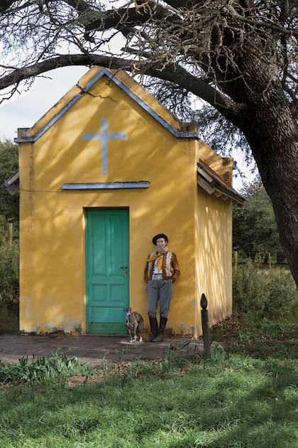 Posa en la capilla del campo donde su padre organizaba una misa y una guitarreada todos los años. Está acompañada por Cachito, uno de sus Whippets. En el altar hay varias fotos de su hijo. Si bien Justo no está de manera física, para ella es fundamental seguir “haciéndolo presente” y honrar su vida. 