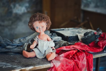 Una muñeca descansa junto a ropas y objetos cotidianos en un hogar abandonado en la Zona de Exclusión de Pripyat