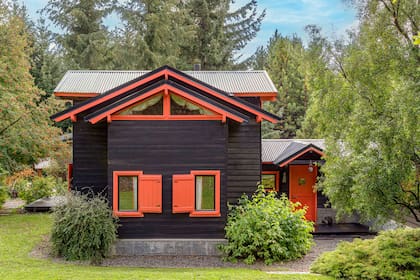 Postigos, vigas y aberturas lucen un anaranjado que resalta sobre la madera oscurecida.