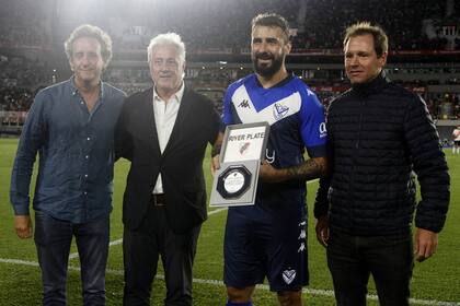 Pratto, con la plaqueta que le entregó River, entre el vicepresidente Patanian y el presidente Brito