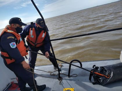 Personal de la Prefectura Naval sube a una embarcación el bolso donde estaba la cocaína