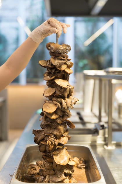 Preparación del shawarma de hongos, especialidad imperdible de la casa.