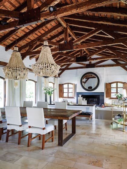 “Preservamos lo que definía identidad, como el techo de 8m de altura con vigas de quebracho traídas del norte”, nos dijo cuando la visitamos en su casa, que compraron prácticamente en estado de demolición y recicló por entero. Sobre el hogar, que se usa hasta para hacer asados, espejo de 1,80m de diámetro.