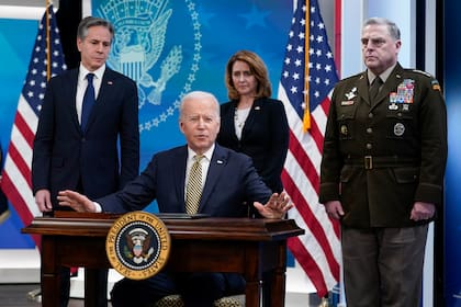 President Joe Biden speaks after signing a delegation of authority in the South Court Auditorium on the White House campus in Washington, Wednesday, March 16, 2022. From left, Secretary of State Antony Blinken, Biden, Deputy Secretary of Defense Kathleen Hicks and Chairman of the Joint Chiefs of Staff General Mark Milley. (AP Photo/Patrick Semansky)