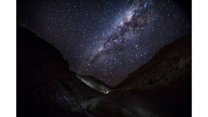 La vía láctea sobre las primeras estribaciones del Valle de la Luna iluminadas por una linterna