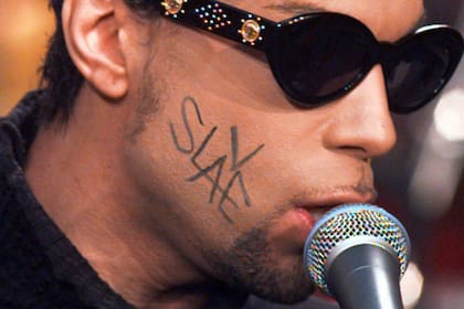 Prince, con la palabra "Slave" escrita en su rostro, actuando en el Rockefeller Plaza de Nueva York, en 1996