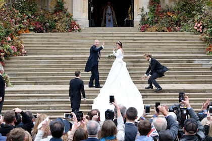 Los diseñadores de la firma Peter Pilotto estudiaron los vestidos que llevaron las duquesas de Cambridge y de Sussex en sus bodas, y el traje que Sarah Ferguson, la madre de la novia, lució cuando se casó con el príncipe Andrés para crear el traje de la princesa. 