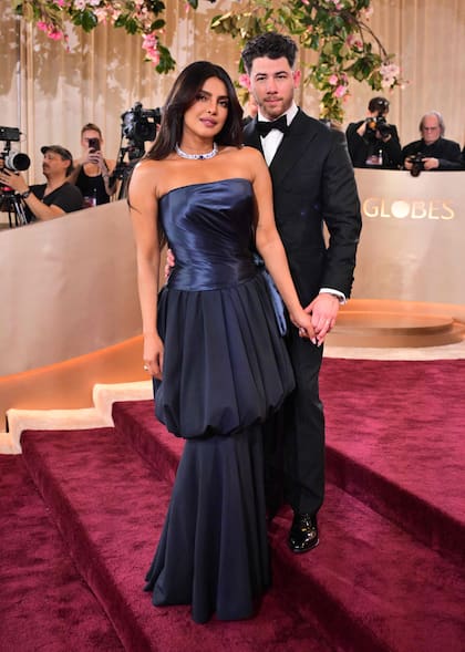 Priyanka Chopra Jonas también fue por los tonos oscuros, pero eligió un azul noche. Junto a su marido, Nick Jonas, deslumbró en un diseño de corsé y sobrefalda globo de satén de Christian Dior que combinó con joyas Bvlgari