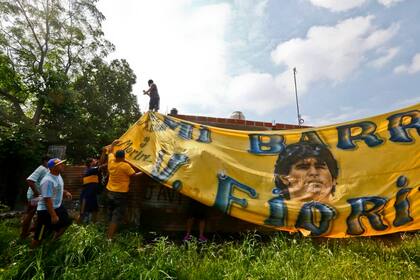 Banderas de los vecinos de Villa Fiorito, en la casa natal de Diego Maradona, en el día de su fallecimiento.