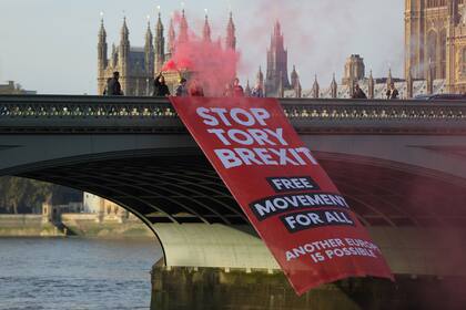 Los manifestantes despliegan una pancarta en el puente de Westminster antes de que comiencen las protestas contra el Brexit, en el centro de Londres