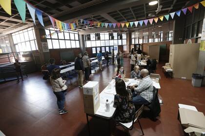 Protocolos en escuelas de Palermo.  Cuartos oscuros abiertos,  alcohol en gel, bandeja para documentos durante la jornada de elecciones legislativas 2021