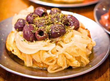 Provoleta con cebolla caramelizada, aceitunas y orégano del bodegón de Club Kimberley