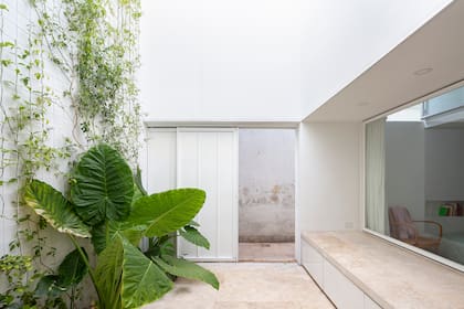 Puerta corrediza abierta al clásico pasillo de los PH en fila, de la cual el de ellos es el último.