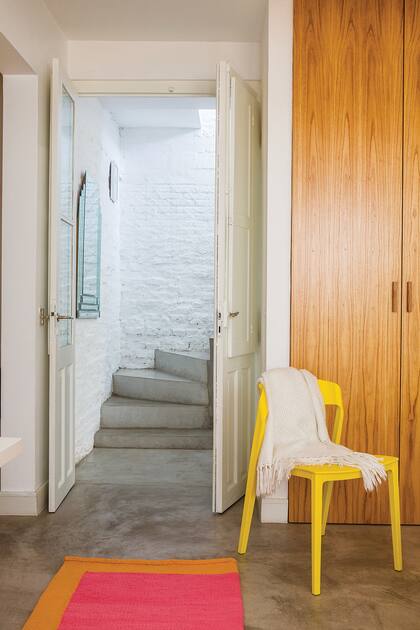 Puerta de doble hoja, rescatada de la obra. Silla amarilla de PVC (Kikely). Alfombra (Elementos Argentinos).