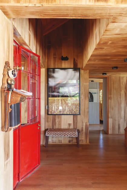 Puerta roja de hierro y vidrio repartido en la casa salteña de Céline Frers.