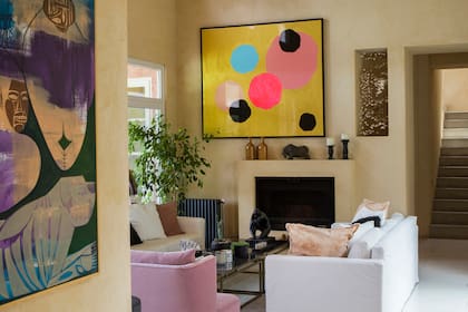 Puertas de demolición dan paso al living, una caja color arena con cielo raso de cañas ambientada con un dúo de sillones en pana y mesas ratonas de mármol.