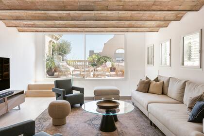 Puff 'Champagne' (Norr11), mesa ratona (Roche Bobois) y sofá a medida (diseño de Verónica Mimoun) sobre una antigua alfombra turca restaurada.