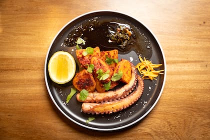 Pulpo confitado del Líbano: dos tentáculos de pulpo español confitado en aceite de cilantro, acompañado con papas libanesas con tomate, especias, y limón.