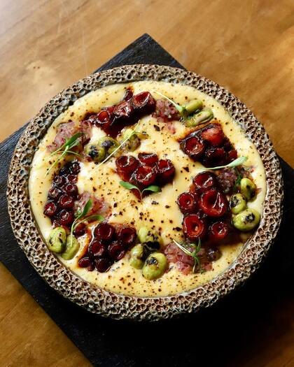 Pulpo crocante en salsa panca miso, espuma de papa amarilla, edamame, aceite de trufa y chalaquita.