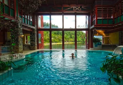 Piscina cubierta con grandes ventanales del Puyuhuapi Lodge.