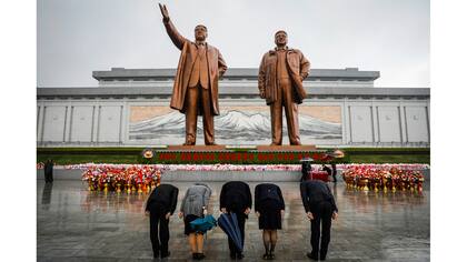La gente rinde homenaje a las estatuas del fundador de Corea del Norte Kim Il Sung y al líder Kim Jong Il en Pyongyang