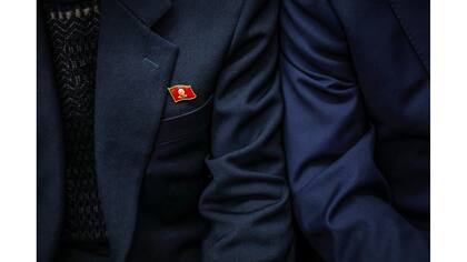 Un pasajero de tren usa un pin de Kim Jong Il