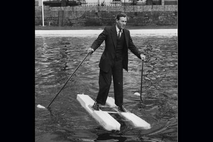 El inventor M. W. Hulton mostrando sus zapatos "marinos" en el Grand Union Canal